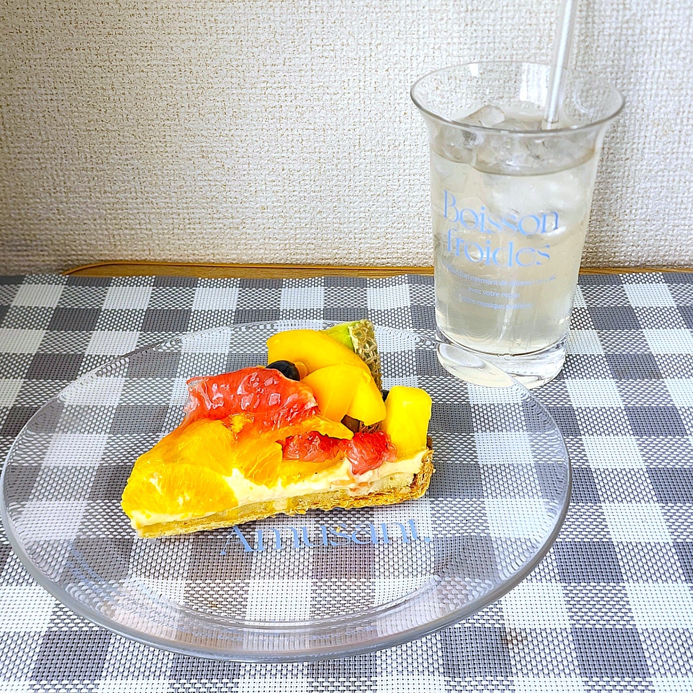 フルーツタルトと炭酸飲料がテーブルの上に置かれている。