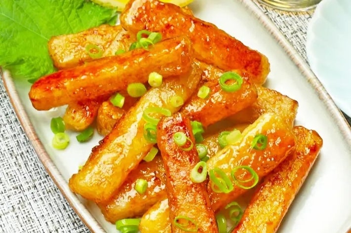 大皿に盛られた揚げたちくわがネギと共に盛り付けられ、添えられたレモンと清涼飲料が見える。