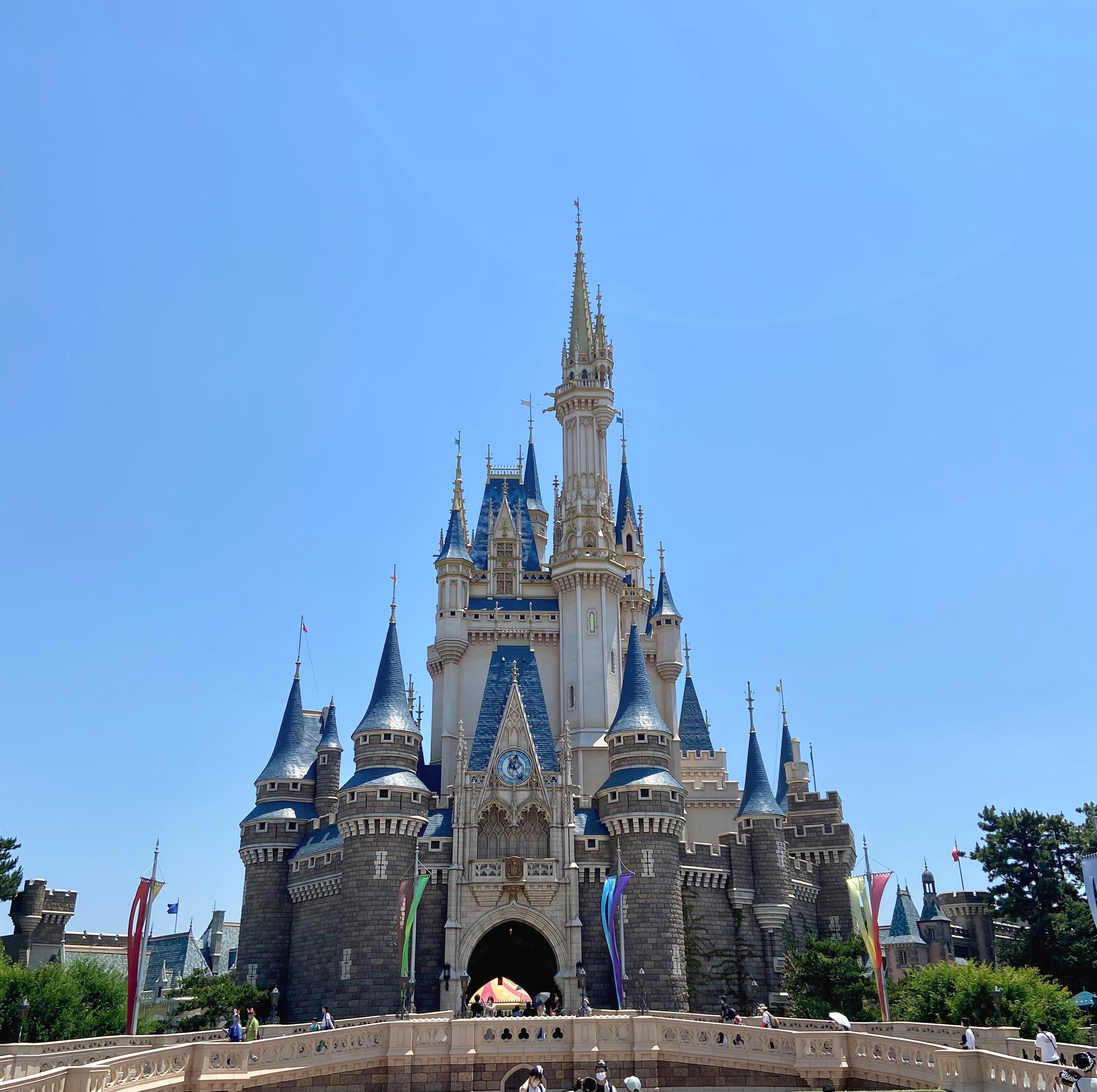 ディズニーランドのシンデレラ城の外観。観光客が城前に集まっている。