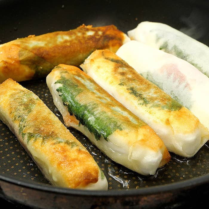 フライパンで調理中の春巻きが5本並んでいる。外はカリっとしており、中の具材が透けて見える。
