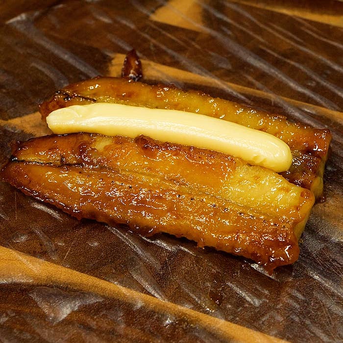 デザートとして提供されるキャラメリゼされたバナナの上に細長いクリームがのった食べ物。