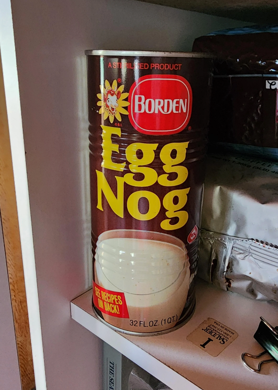 Borden Egg Nog can on a shelf, labeled as a sterilized product, 32 fluid ounces