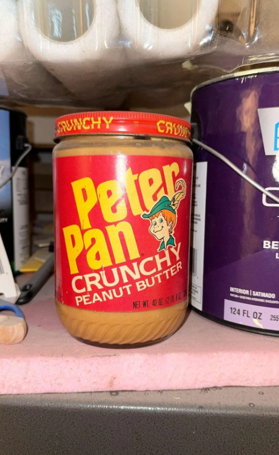 Jar of Peter Pan Crunchy Peanut Butter stored on a shelf