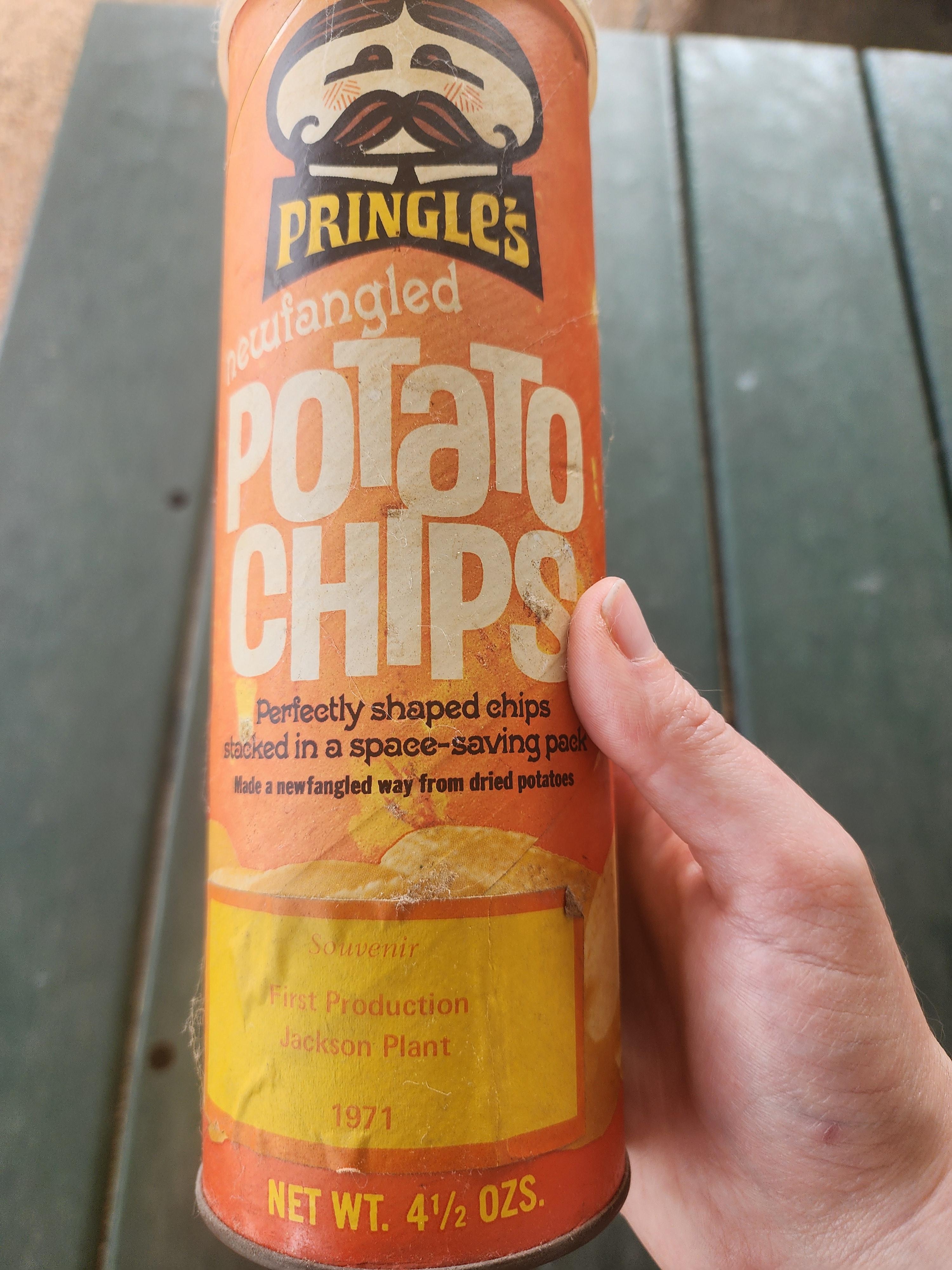 Close-up of a vintage Pringles can. Text mentions "newfangled" potato chips, 1971 production, and Jackson Plant