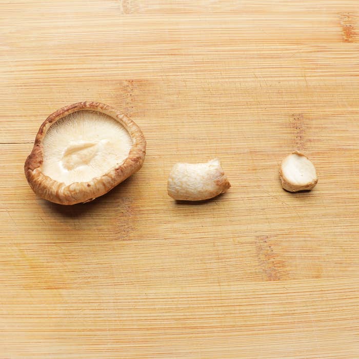 まな板の上に置かれた異なる大きさのしいたけ3つ。