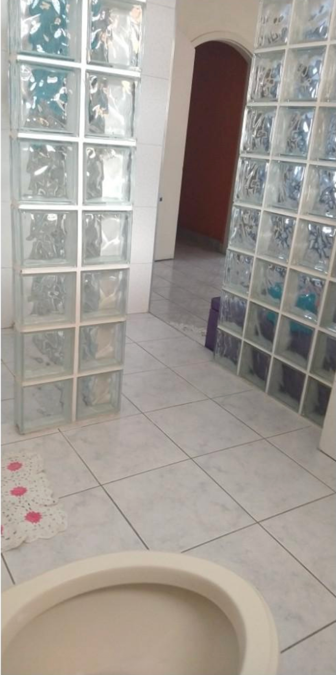 Bathroom with glass block walls, tiled floor, and a white sink; there is no door