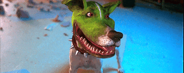 A dog with a green-painted face, spiky collar, and wide grin looks around excitedly