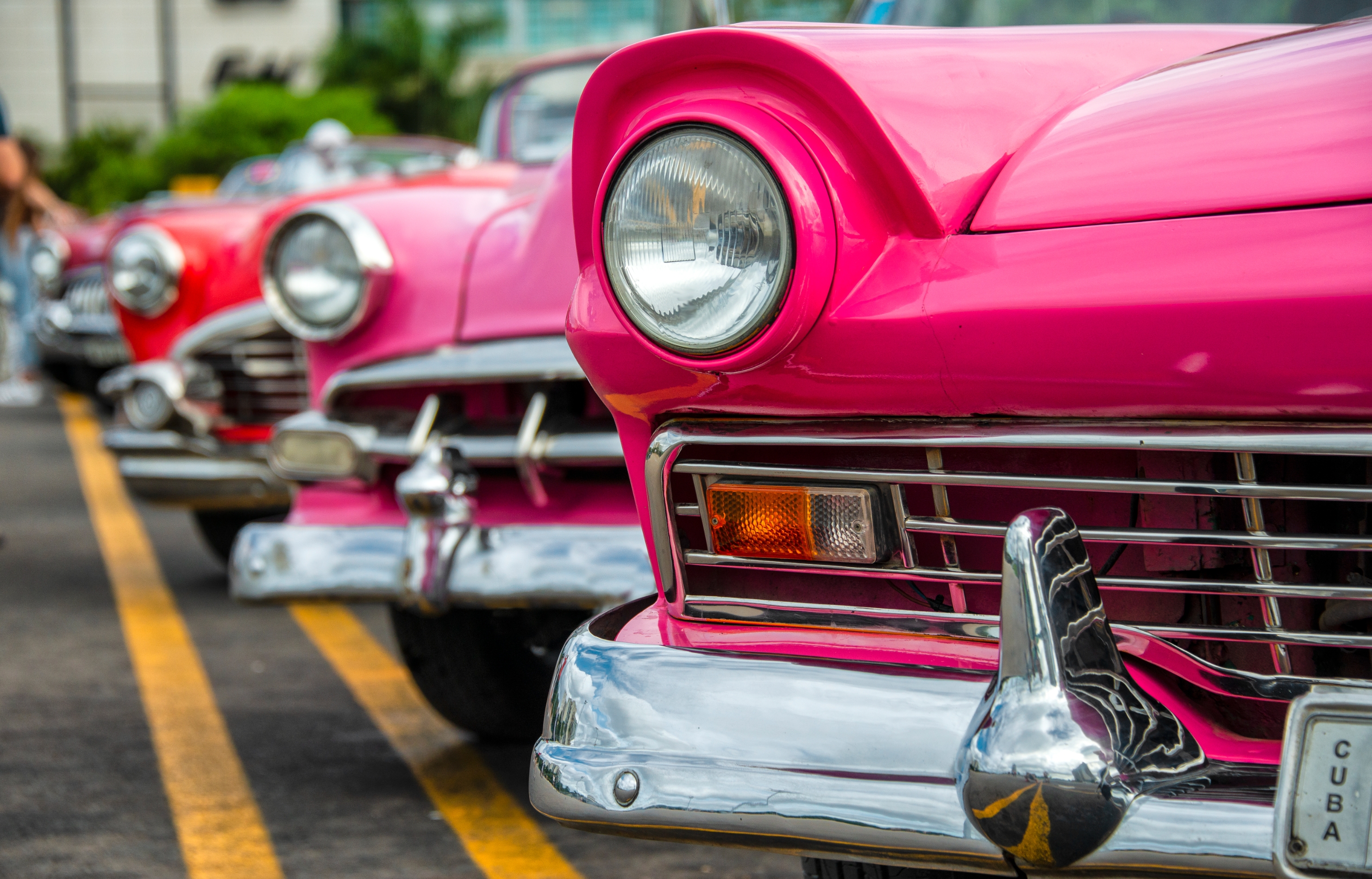 Classic cars parked in a row, emphasizing vintage design elements such as chrome bumpers and round headlights