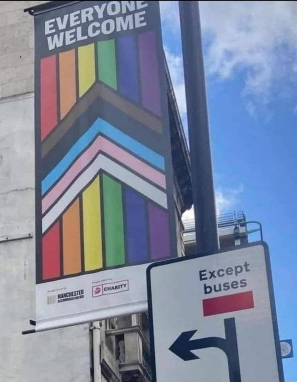 Banner reads "Everyone Welcome" with LGBTQ+ flag colors; below, a street sign says "except buses"