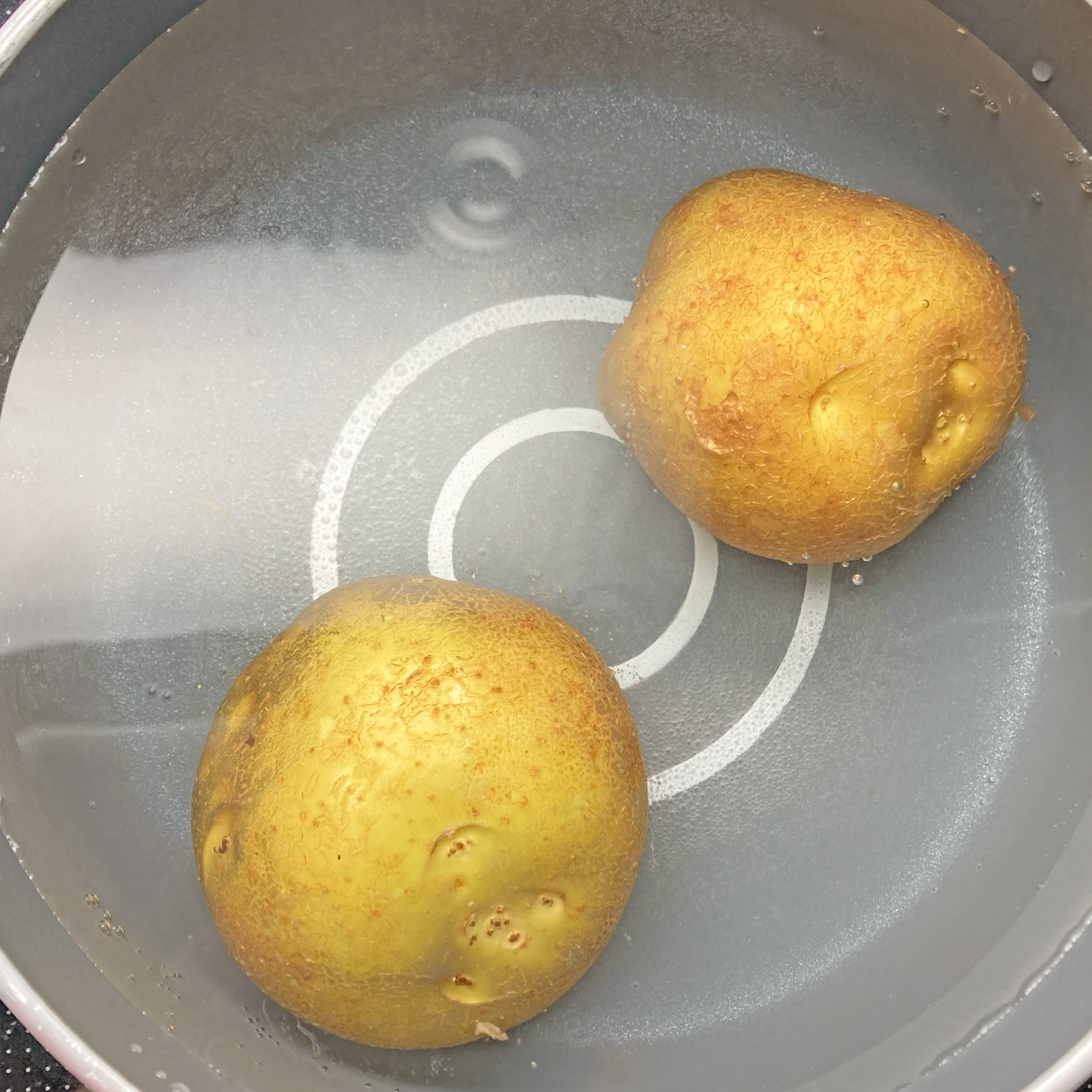 鍋に水とジャガイモ2個が入っています。