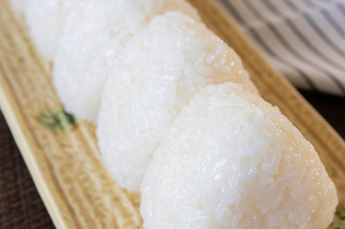 陶器の皿に盛られた数個のおにぎり。