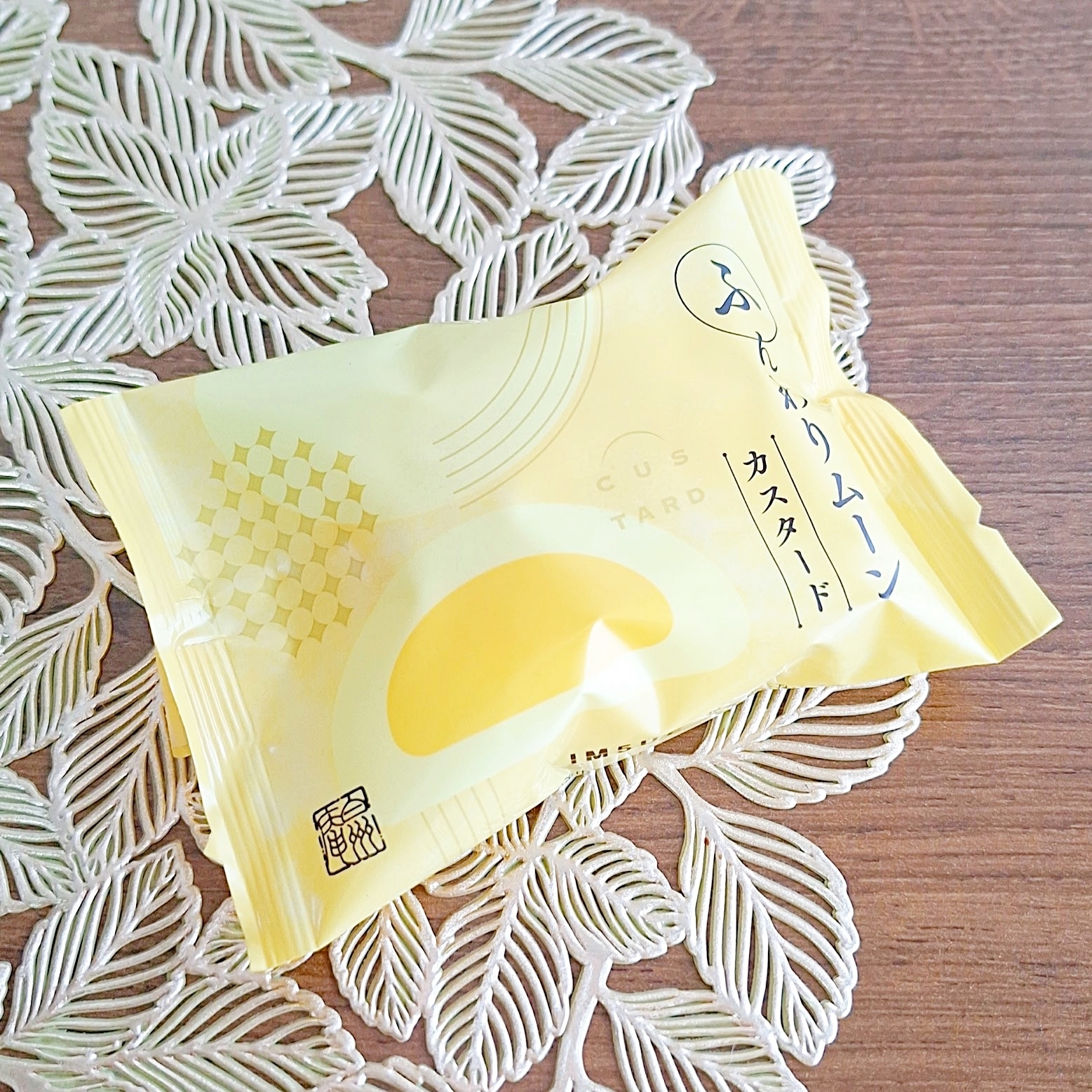 カスタードムーンという名前のカスタードお菓子がプラスチック包装に包まれてテーブルの上に置かれています。