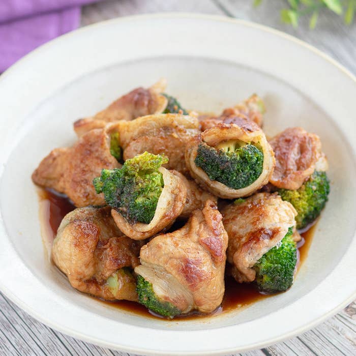 ブロッコリーと肉の巻物が皿に盛られた料理。