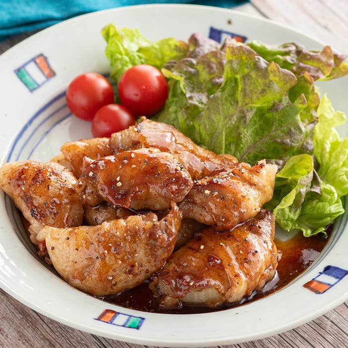 タレで味付けされた焼き鳥が皿に盛られており、レタスとミニトマトが添えられている。