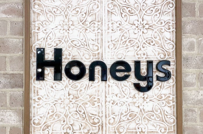 背面に装飾が施された壁にある「Honeys」という文字のロゴ。