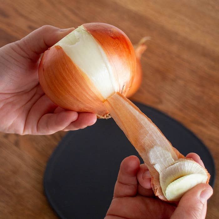 玉ねぎの皮を剥いている手元のクローズアップ。