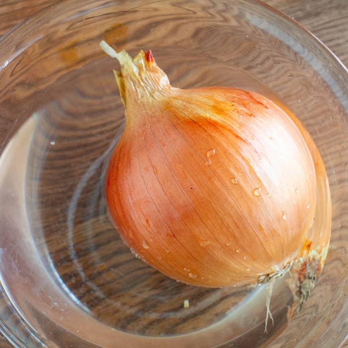 ガラス製のボウルに入ったタマネギが置かれている。