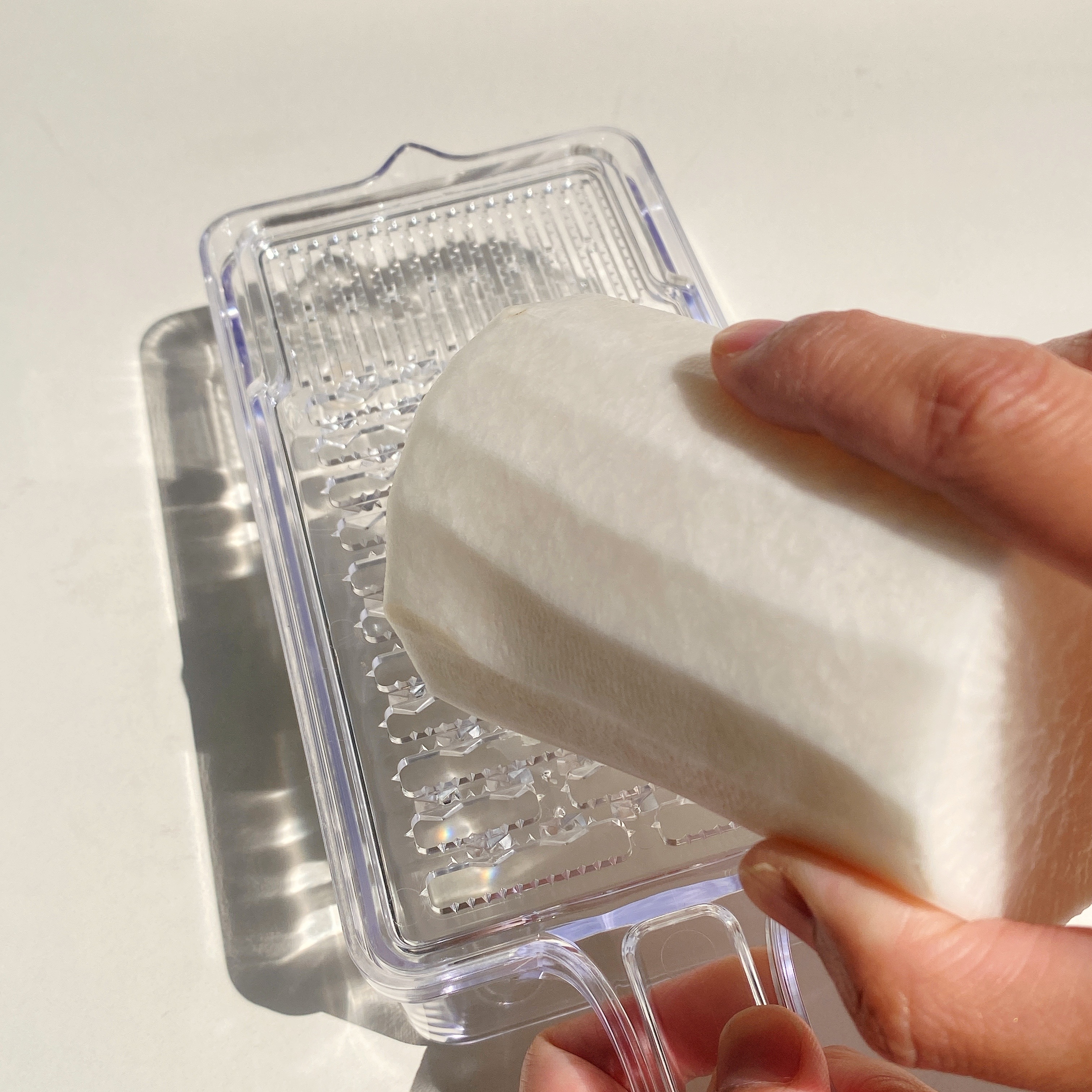 大根をおろし器ですりおろしている手元。