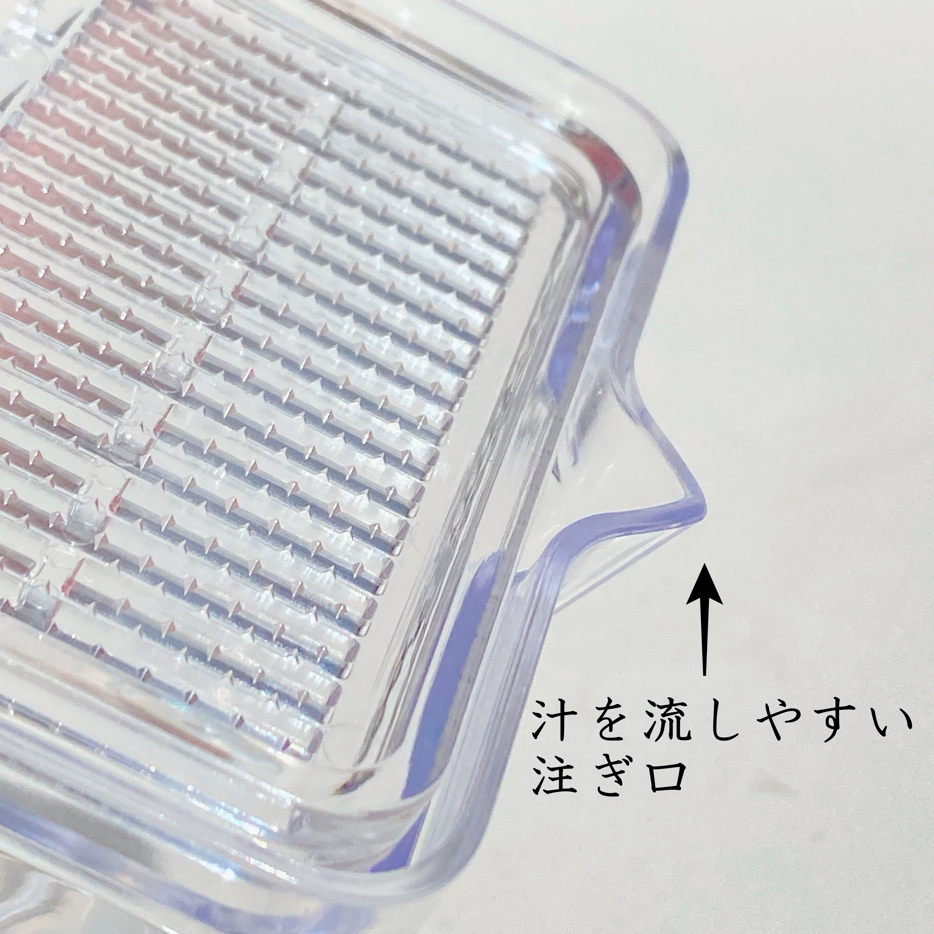透明な器は、液体を注ぎやすい注ぎ口が付いていることを示しています。器の説明として日本語で「汁を流しやすい注ぎ口」と書かれています。