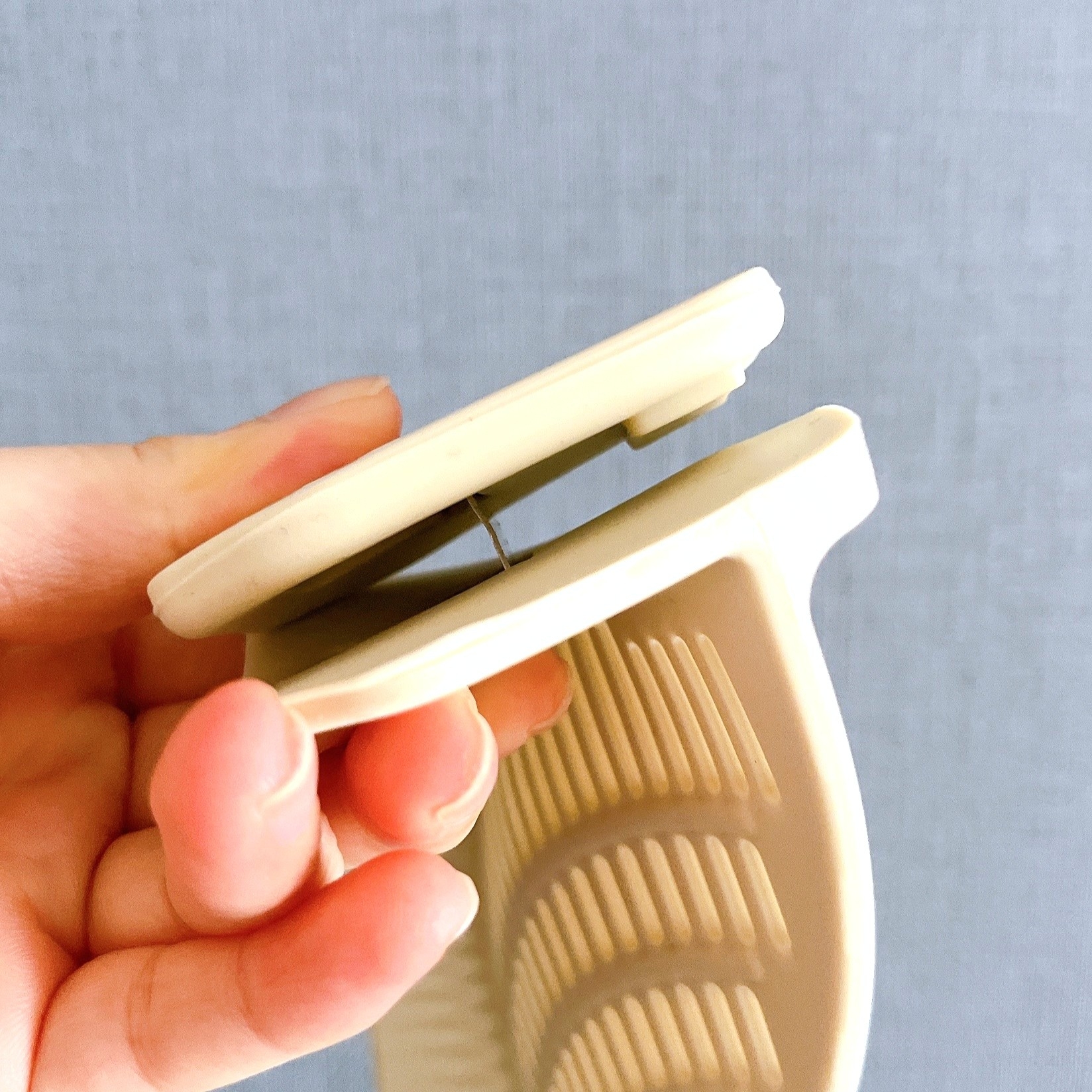 手に持たれたクッキーや生地をカットするためのプラスチック製のハンドル付き道具。