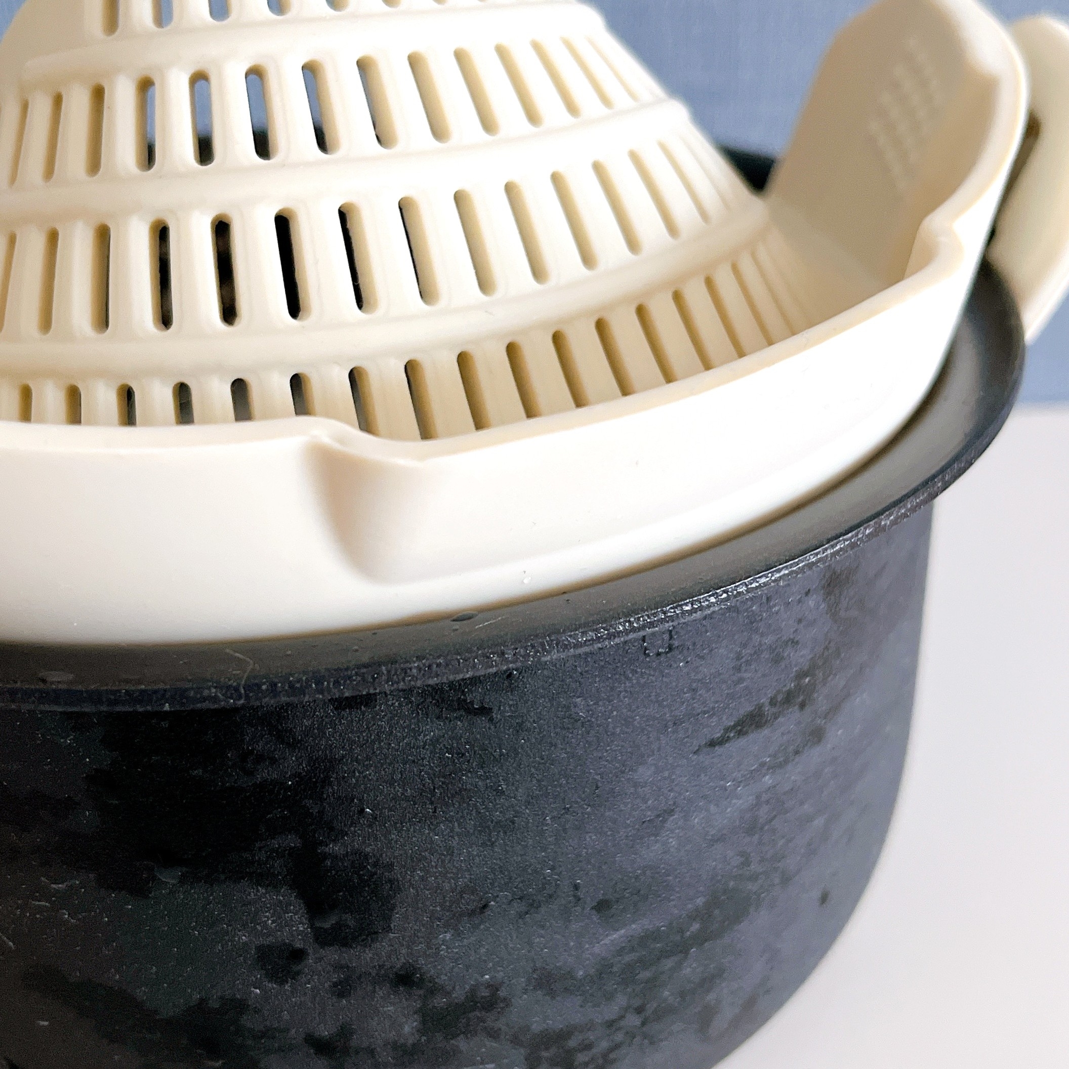 鍋の中にプラスチック製のザルが置かれているキッチン用品の写真。