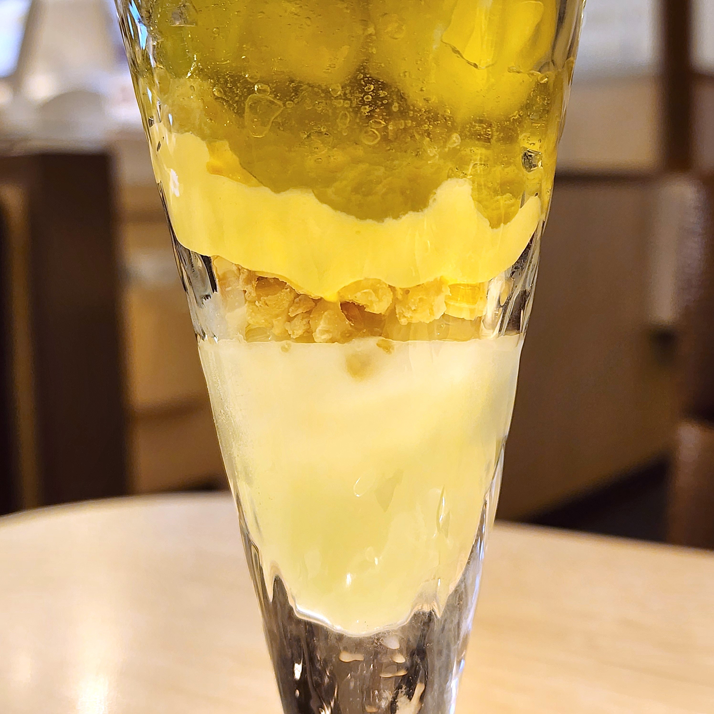 長いグラスにアイスクリーム、コーンフレーク、ゼリーが層になっているデザート。