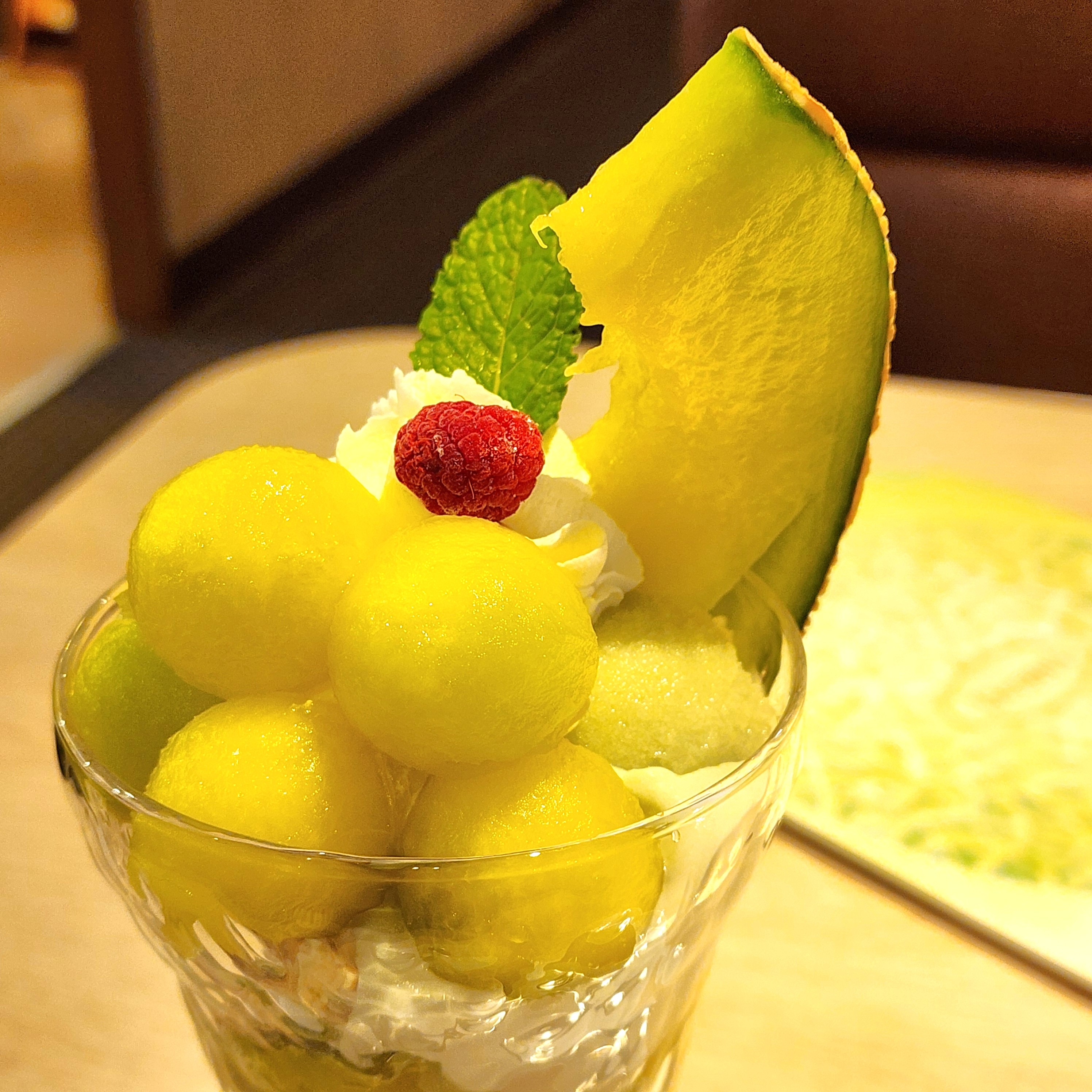 メロンボールとホイップクリームがのったフルーツパフェ。