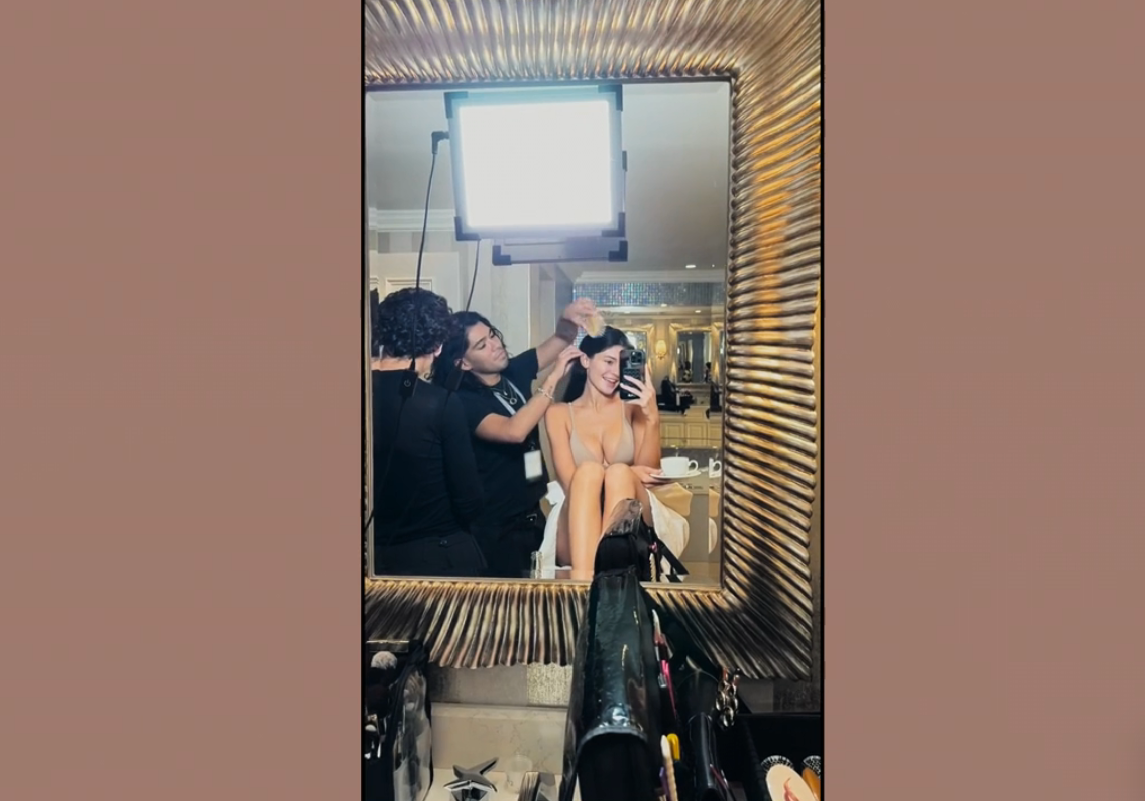 TikTok screenshot of Kylie seated in front of a mirror having her hair styled