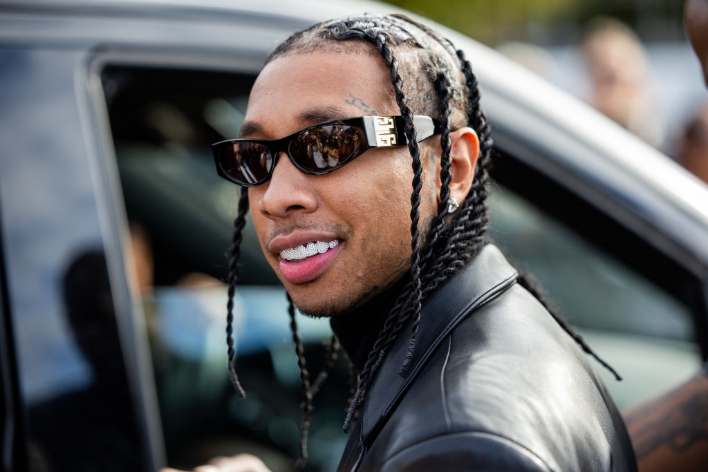 Tyga by a car smiling