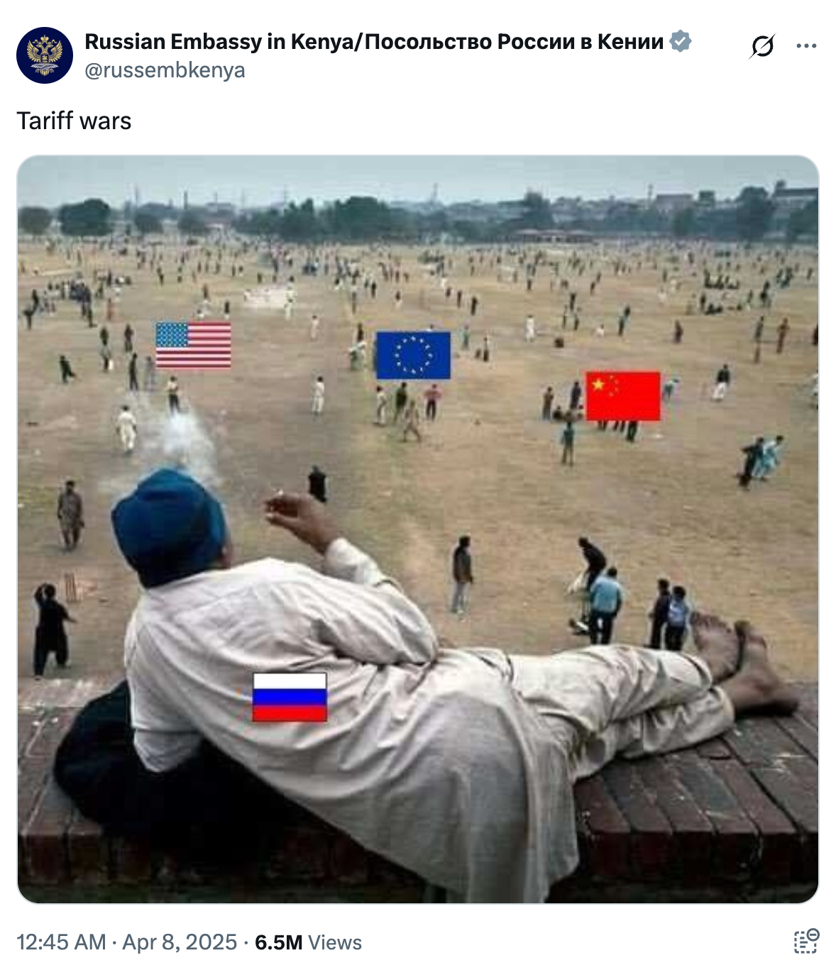 Person relaxes on wall, watching groups with U.S., EU, China flags in field. Russian flag on person's back. Caption reads: "Tariff wars."