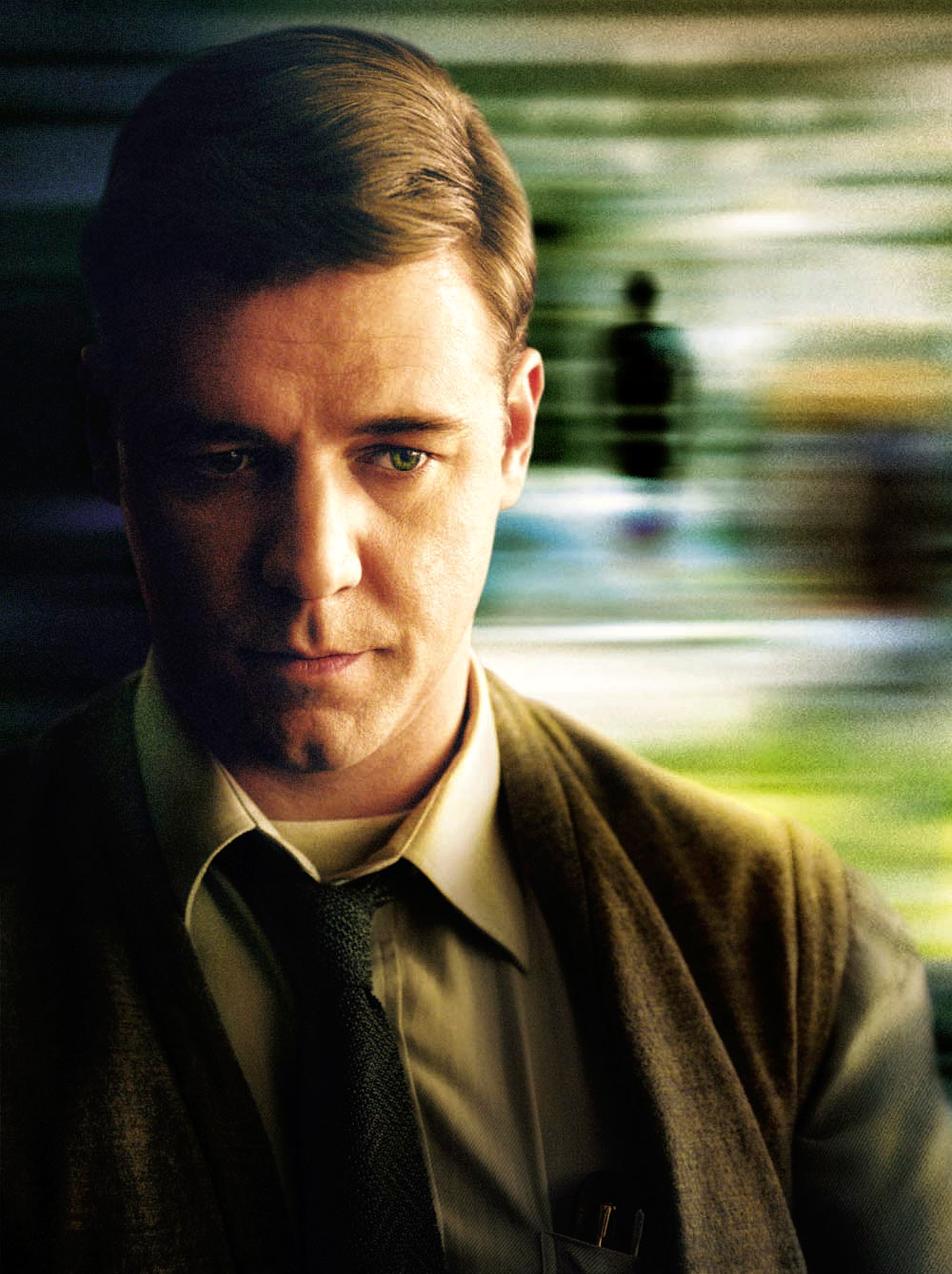 Person in a suit and tie looks introspective with a blurred background suggesting thought or memory