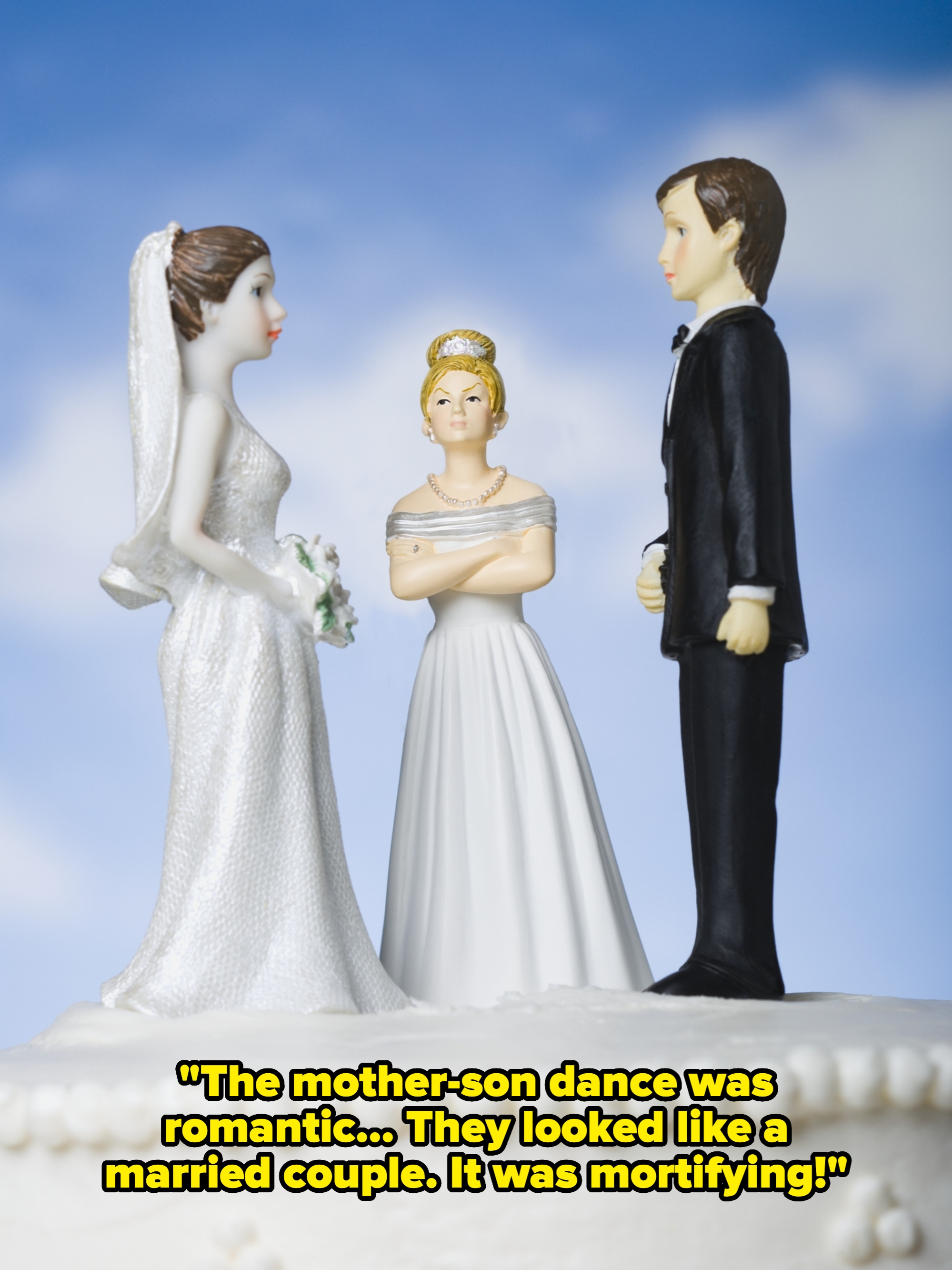 Wedding cake topper with a bride and groom facing each other and a displeased woman in a gown standing between them, arms crossed