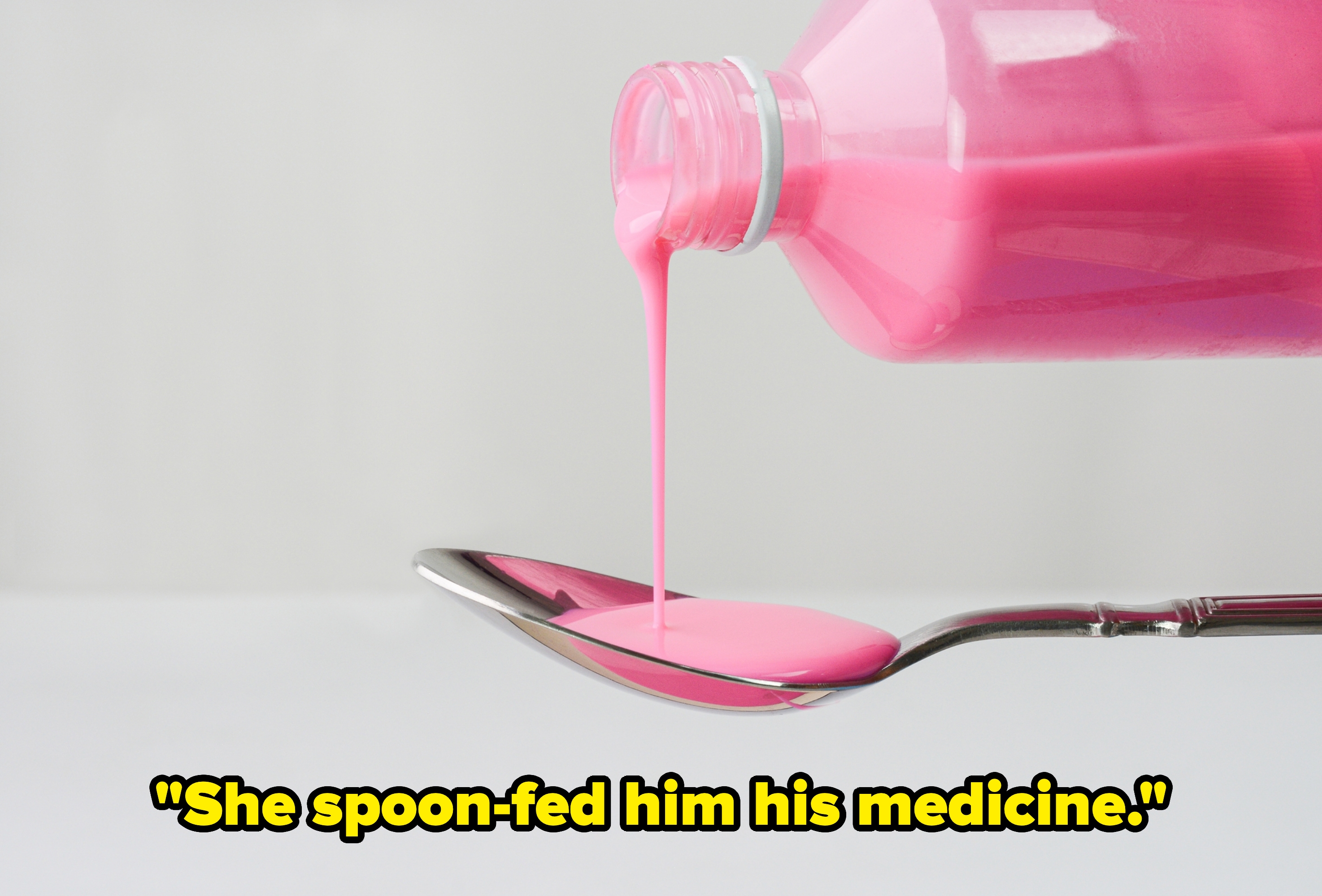 Pink liquid being poured from a bottle onto a spoon