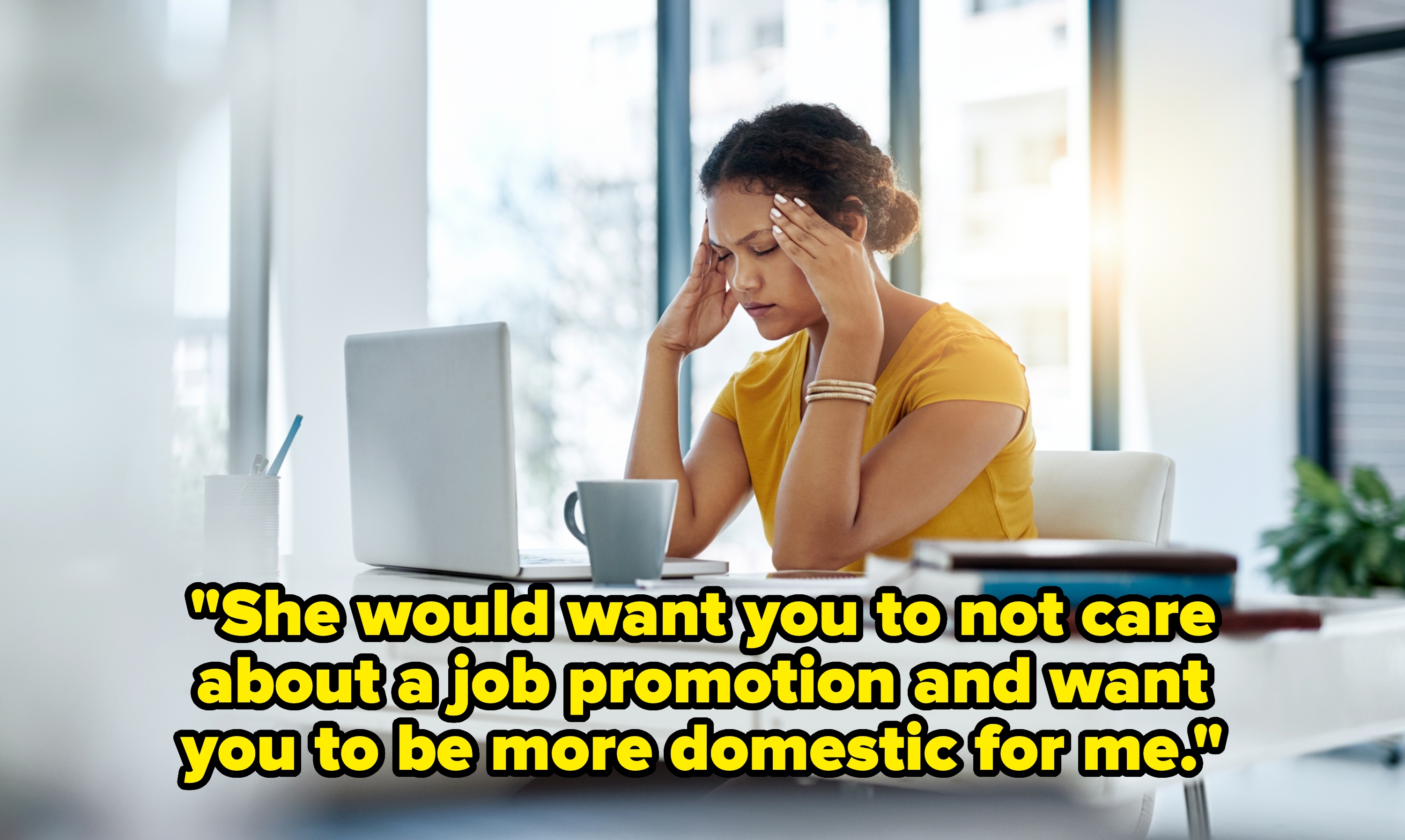 Person sits at a desk with a laptop, holding their head in their hands, looking stressed. A coffee mug and books are nearby