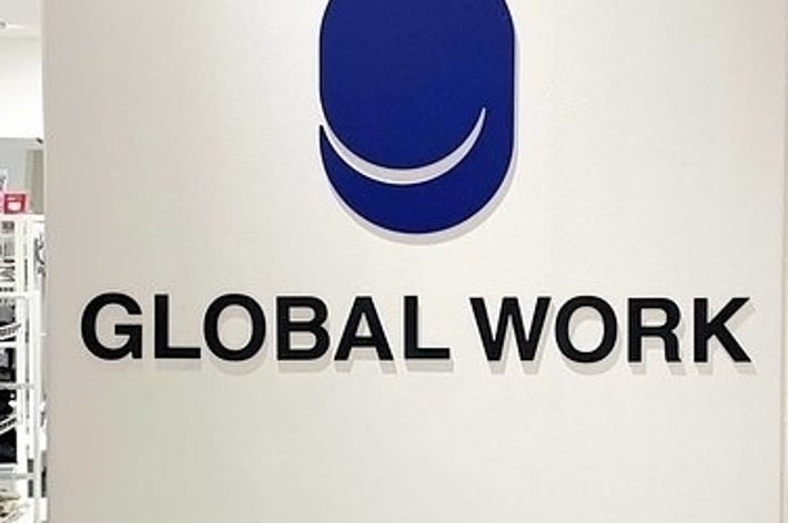 白い壁に「GLOBAL WORK」のロゴがあり、周囲に洋服が陳列されている店舗内。
