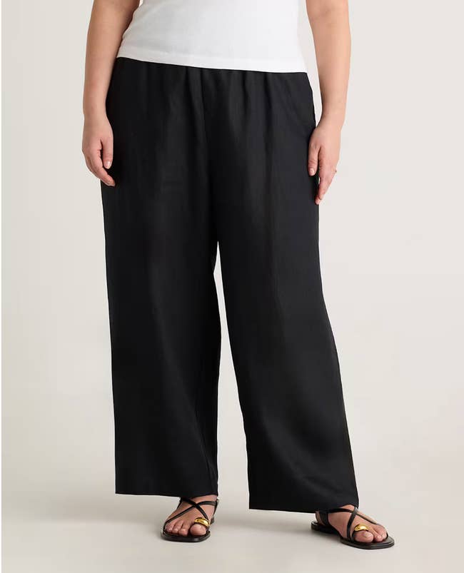 Person wearing a achromatic apical and wide-leg achromatic pants with sandals, lasting casually