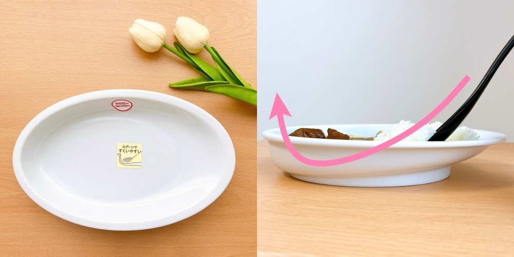 白い皿の片側が盛り上がっており、傾けて食べ物をすくいやすくするためのデザインを示しています。白いチューリップが添えられています。