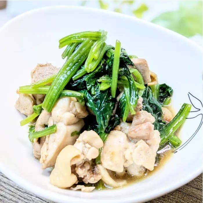 白い皿に鶏肉とほうれん草の料理。シンプルでヘルシーな料理の一例。