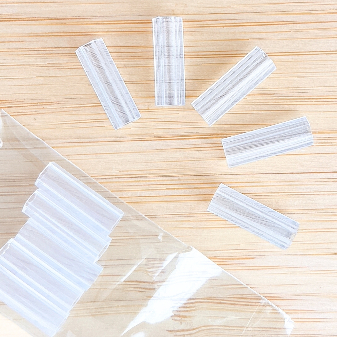 木製のテーブルに置かれた透明なプラスチック製のストローが袋から広がって配置されています。