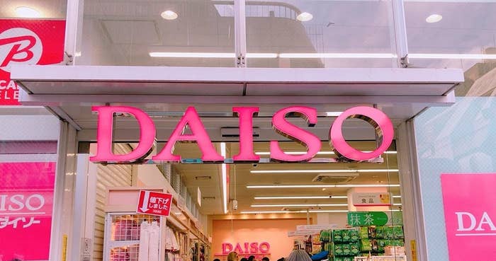 人々が店内を歩くダイソーの入口。商品棚には様々な商品が並んでいる。