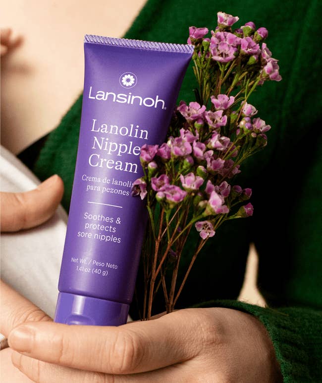 model holding a babe and a Lansinoh Lanolin Nipple Cream tube, alongside substance promoting its natural, ultra-pure, hypoallergenic qualities