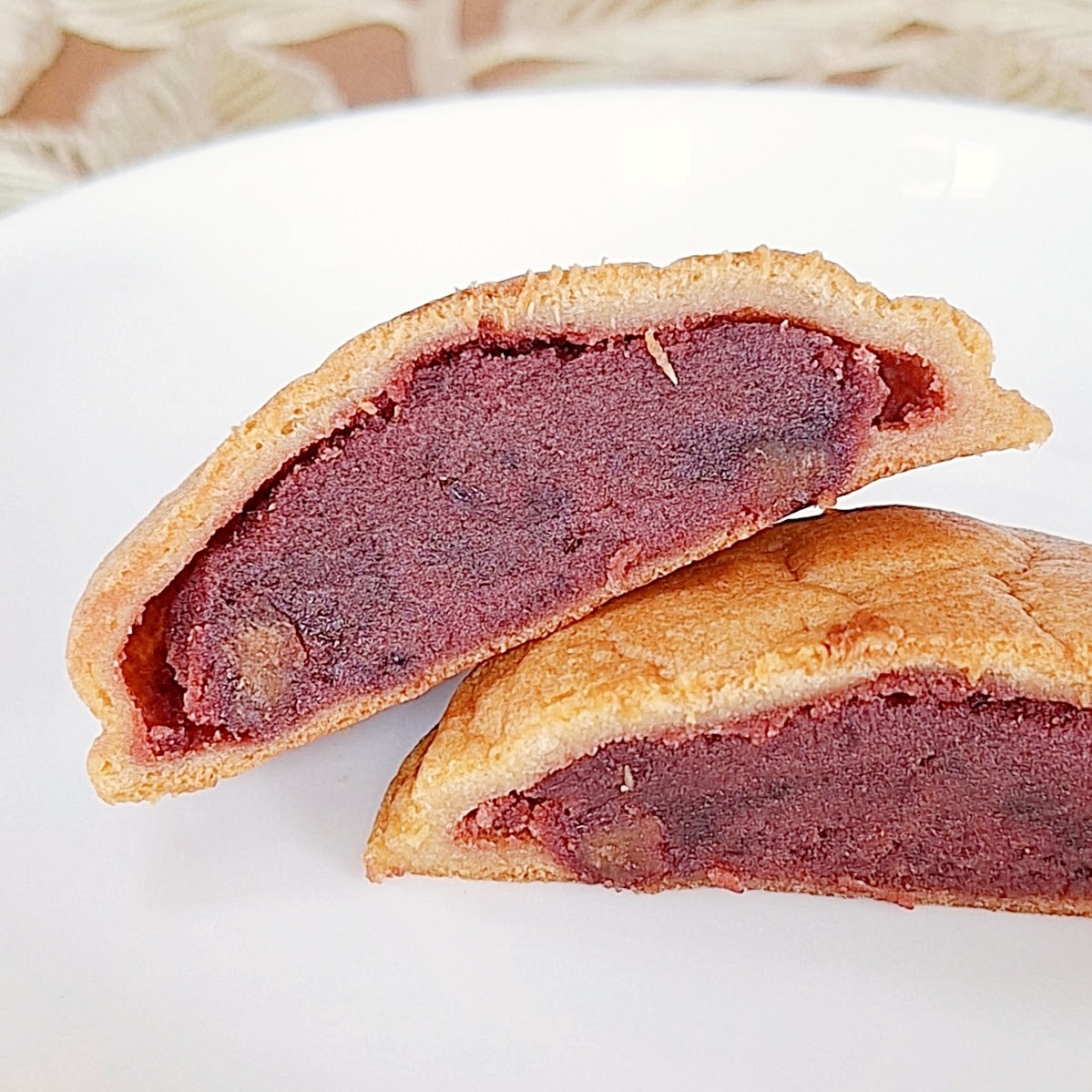 白い皿に盛られた二つに割ったどら焼き、中にアンコがたっぷり。