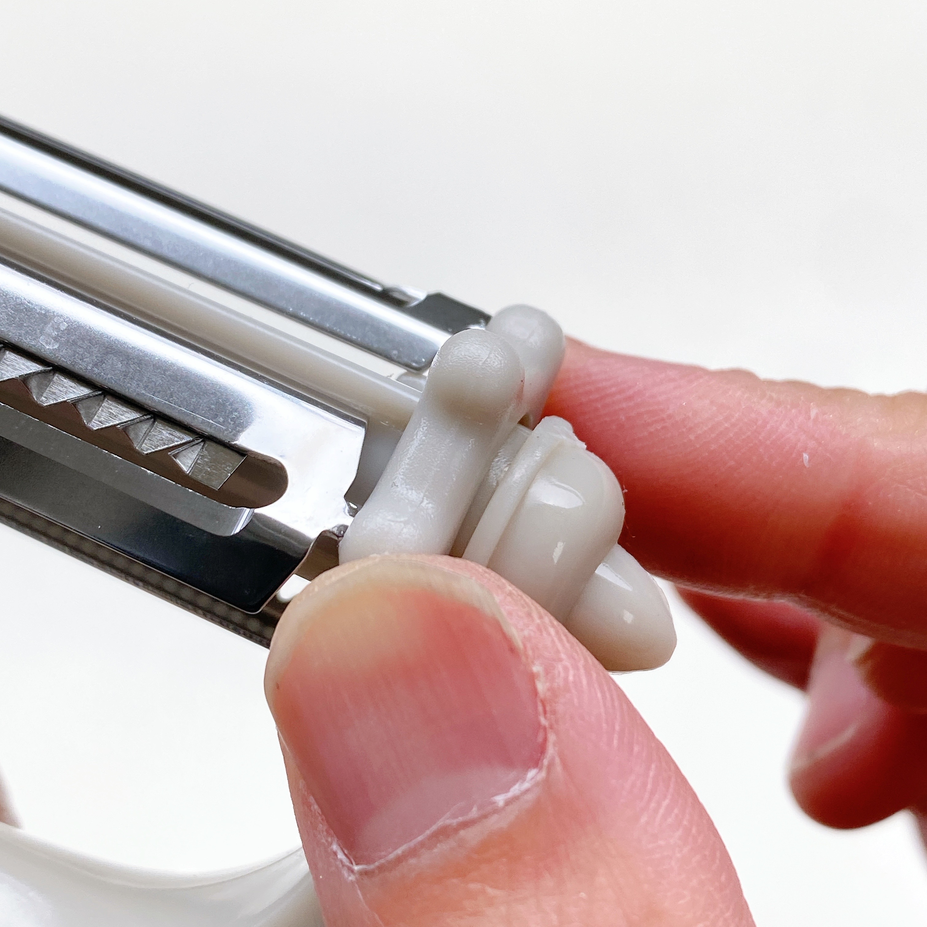 金属製のピーラーを持っている手のクローズアップ。