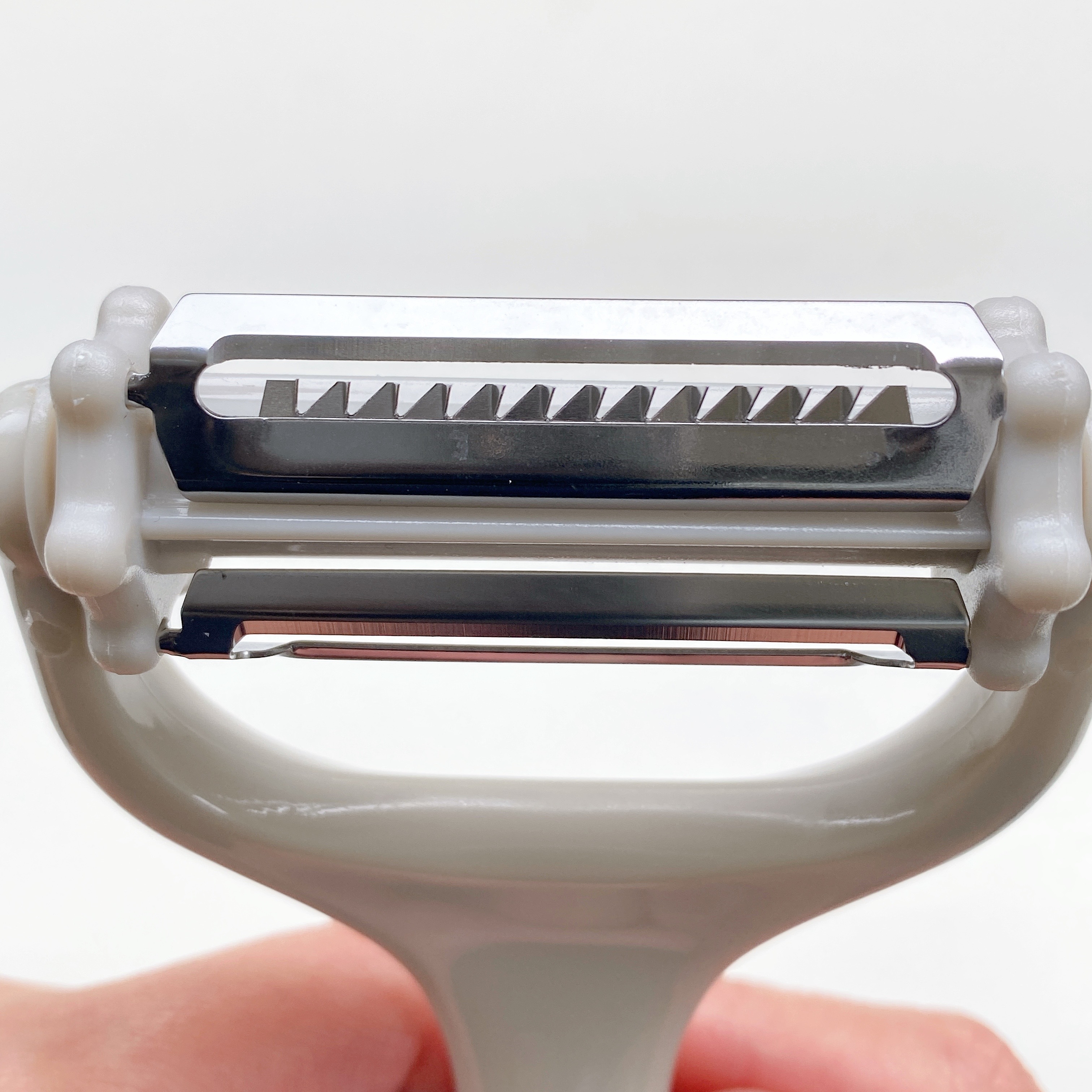 白いハンドルの付いた2枚刃のシェーバーのクローズアップ。シンプルで機能的なデザイン。