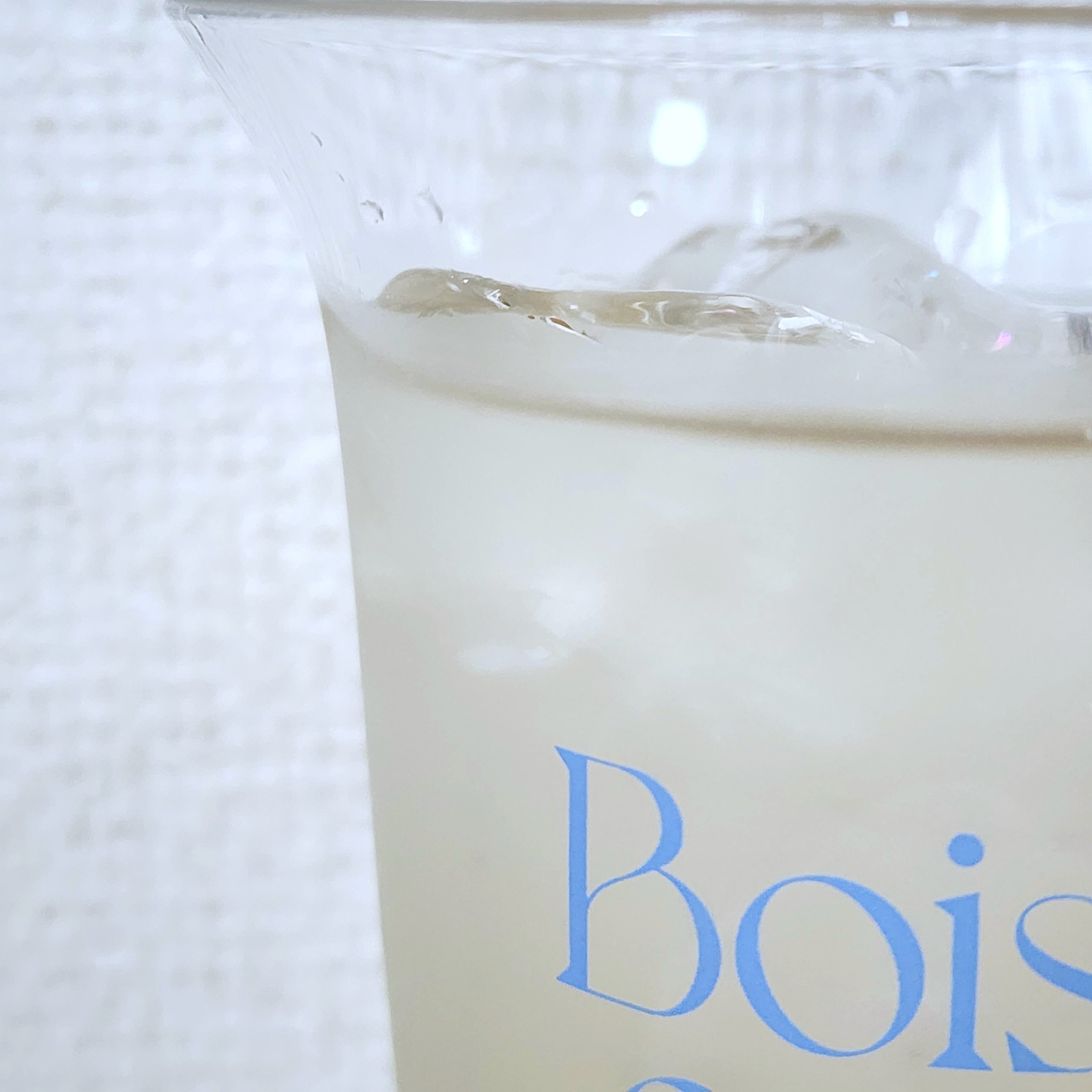 カップに注がれた冷たい飲み物があり、背景に「Bois」の文字が一部見える。
