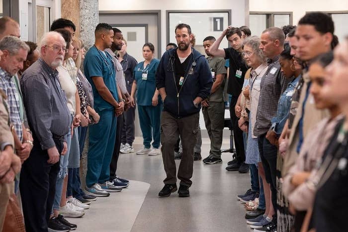 Robby walking down the hallway in the hospital surrounded by numerous people lining the hall
