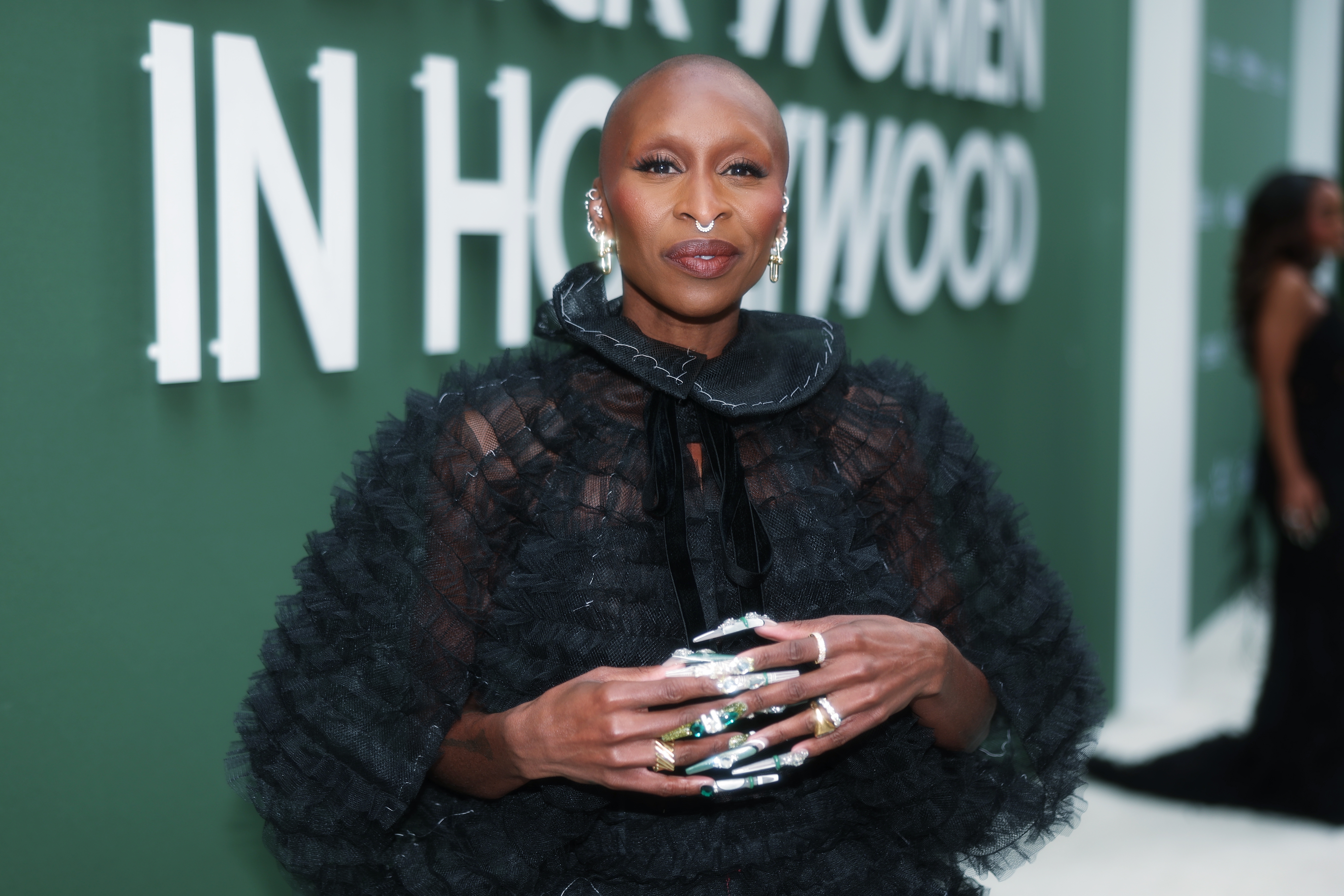 Person on a style event red carpet wearing a textured, ruffled gown with large rings and statement earrings