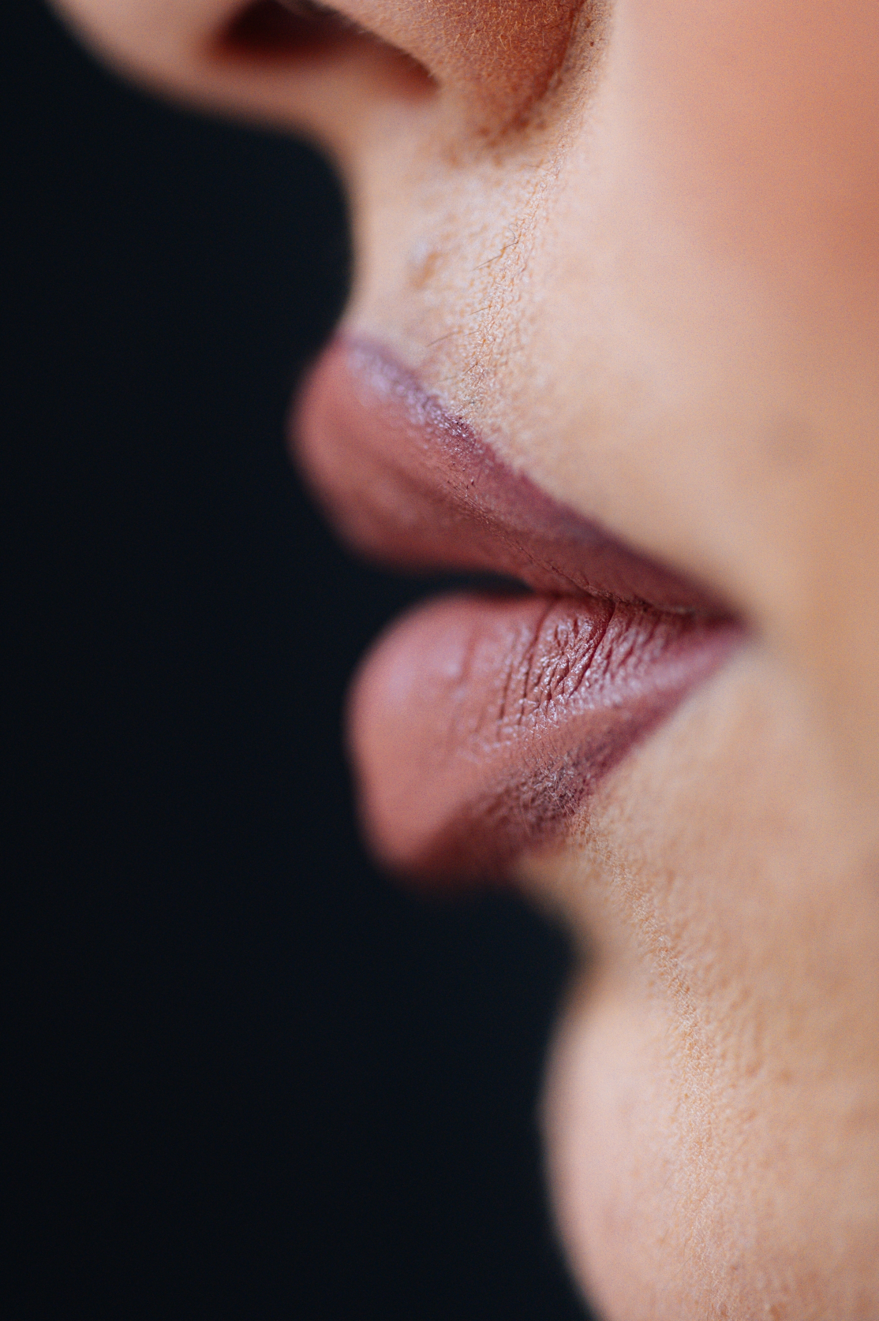 Close-up of a person's lips and nose, highlighting smooth skin texture and natural lip features