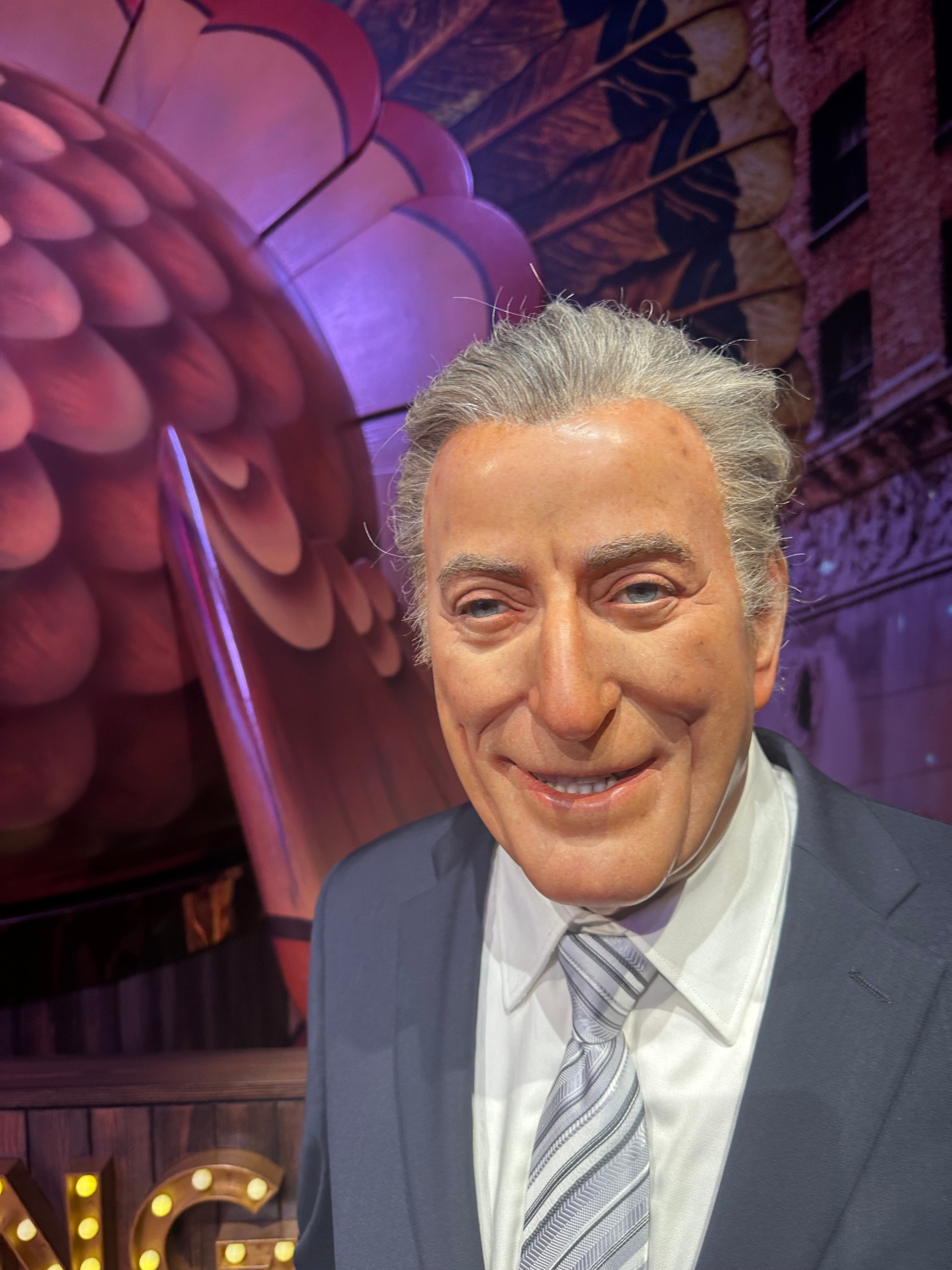 Person in suit with a festive backdrop, possibly a parade float, suggesting a celebratory event related to travel or a holiday parade