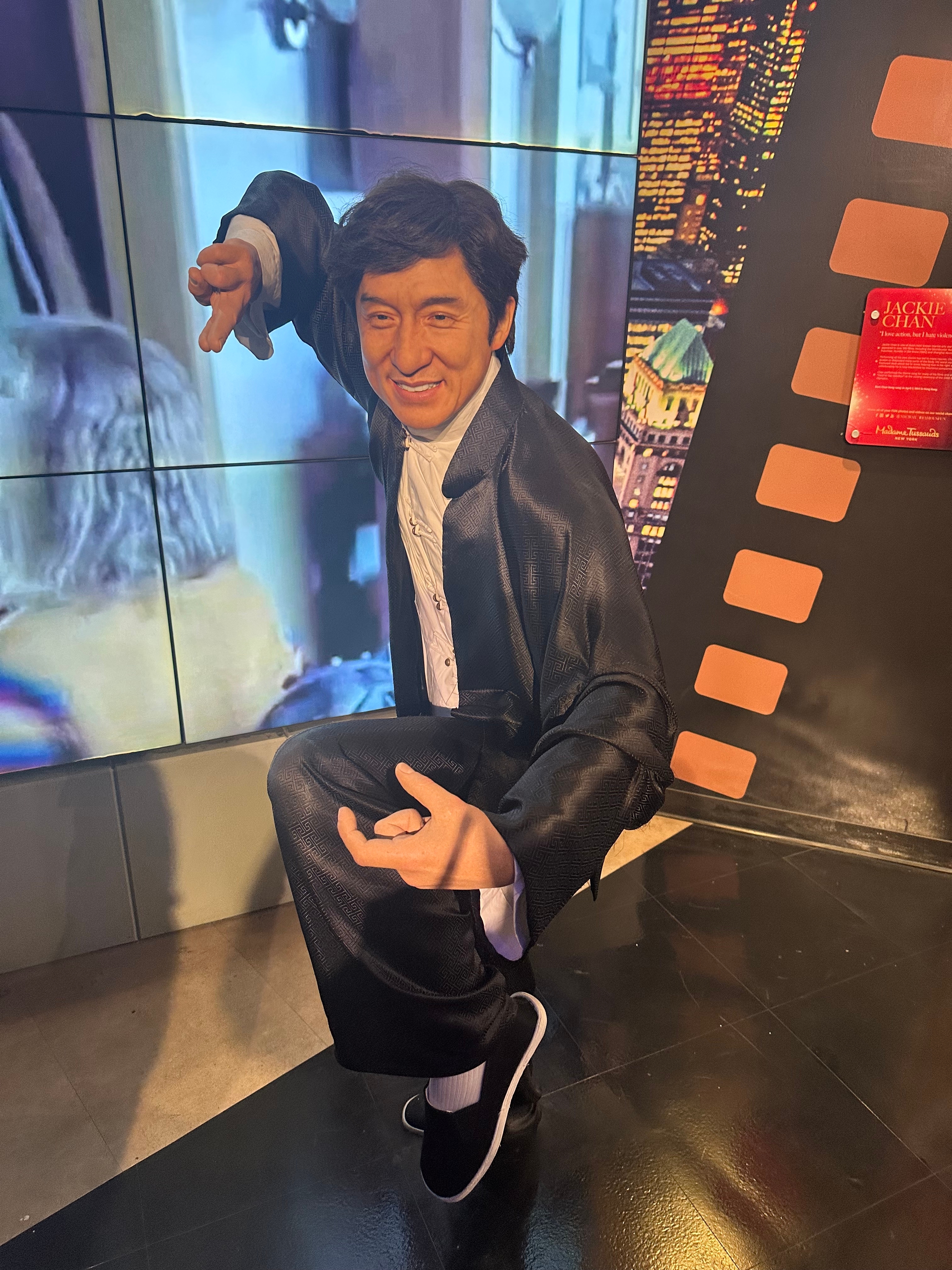 Wax figure in a martial arts pose in a museum setting, showcasing dynamic movement